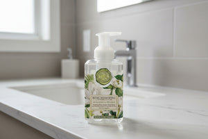 Clear bottle of Michel Design Works hand soap with floral design on a white background