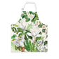 A cotton apron with a floral pattern featuring magnolia flowers and green leaves.